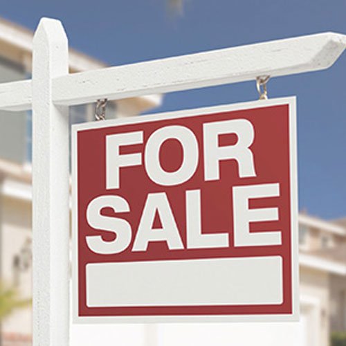A bright red "For Sale" sign stands in front of a charming house-Property Nation