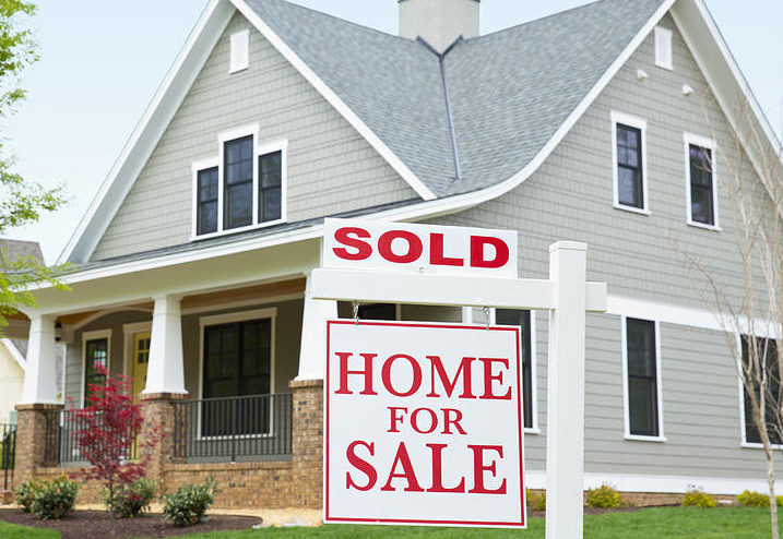 house with sold sign in front yard ariel skelley-Property Nation